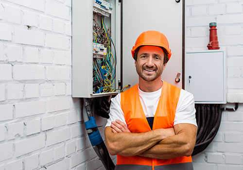 electrical worker standing next to fuse box